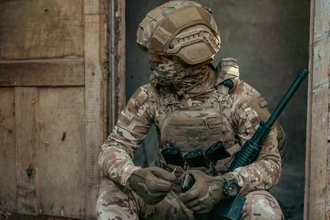 A soldier is loading cartridges into a machine gun magazine. Stock Photos
