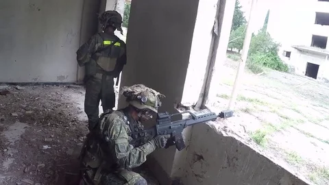 Soldier loading rifle inside derelict building during live fire exercise Stock Footage 93390171