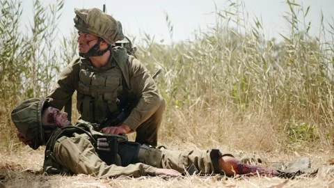 Soldier looking around lays down head colleague and drags seriously Vídeos de archivo 169262458