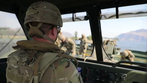 Soldier looking out from cab of bridge erection boat towards soldiers  Видео 160106788