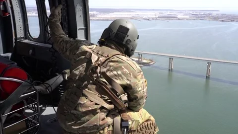 Soldier looking out from helicopter at collapsed Scott Key Bridge Stock Footage 270530689