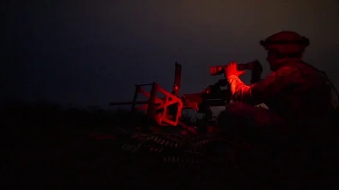 Soldier looking through machine gun sights at night Stock-Footage 82694562