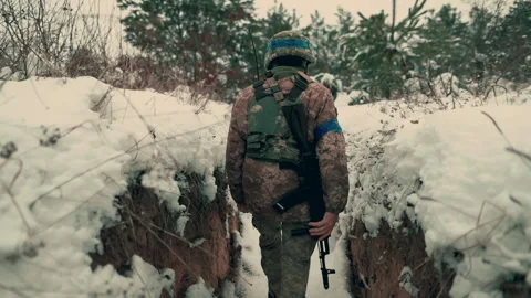 A soldier with a machine gun walks along the trench. Stock Footage 260320789