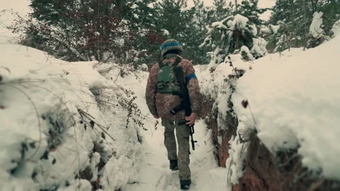 A soldier with a machine gun walks along the trench. Stock Footage 260320844