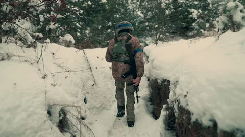 A soldier with a machine gun walks along the trench. Stock Footage 260320850