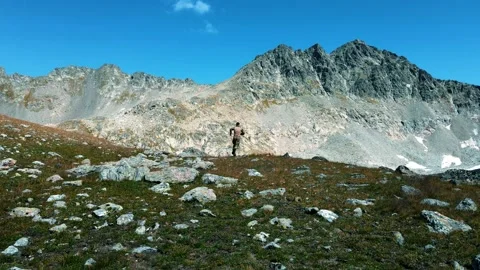 A soldier in a multicam quickly runs in the mountains to the lake Stock Footage 138442335