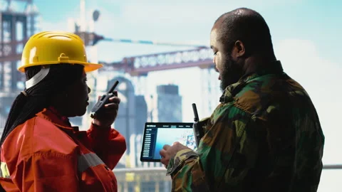 Soldier on offshore platform deck talking with technician, using device Stock Footage 319973609