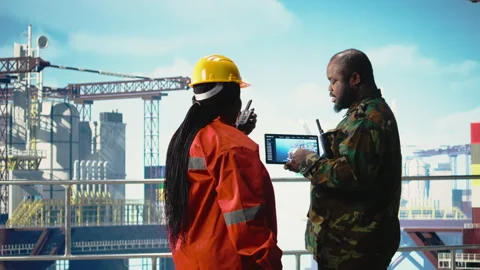 Soldier on offshore platform deck talking with technician, using device Stock Footage 319975683