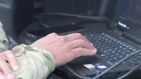 Soldier operates a laptop computer to control an autonomous tactical vehicle Stock Footage 334314473