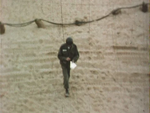 Soldier with paper walking on beach and into tent - vintage 8mm Stock Footage 79268259