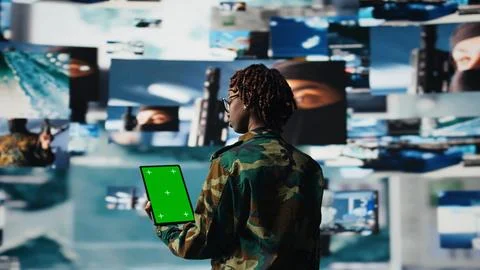Soldier providing combat support using reconnaissance feeds on mockup tablet Foto stock
