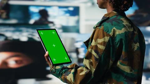 Soldier providing combat support using reconnaissance feeds on mockup tablet Stock Photos