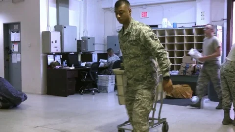 Soldier pulls trolley laden with parcels at Incirlik post office Stock Footage 91248216