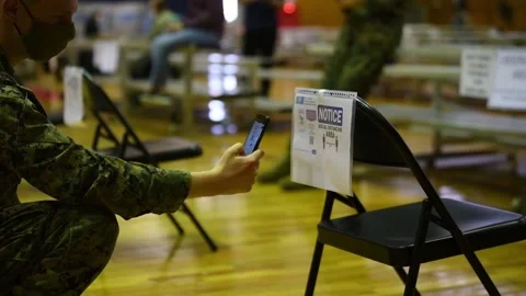 Soldier scanning QR code with Smartphone to register for Covid-19 vaccination Stock Footage 150351801