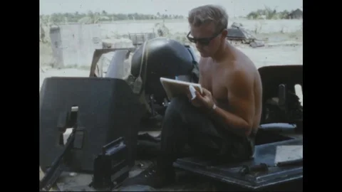 Soldier seated atop M- 113 APC writes a letter and listens to radio - 1969 Stock Footage 106050366