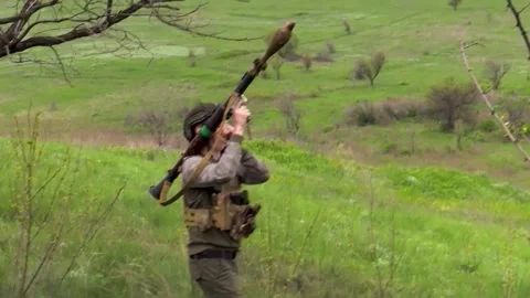 A soldier shoots from a hand-held anti-tank grenade launcher on the battlefield Stock-Footage 240699853