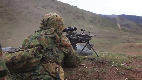 Soldier shoots a machine gun while lying Video stock 121791370