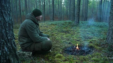 A soldier sits by a dying campfire 스톡 동영상 301712265