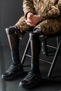 A Soldier Sitting with Advanced Bionic Leg Prosthesis in Tactical Attire Stock Photos