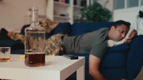 Soldier sleeping on sofa after drinking alcohol, mental health problems, crisis Stock Footage 258282483
