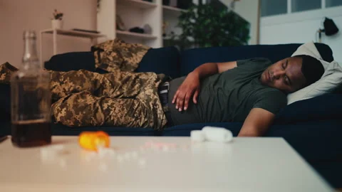 Soldier sleeps on sofa after taking drugs with alcohol, mental health problems Stock Footage 258282533