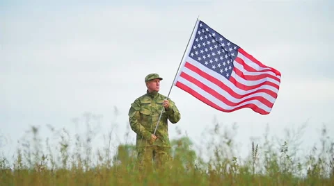  Soldier  stand  without movement  in field  with  American flag . Slow motion  Stock Footage 53098134