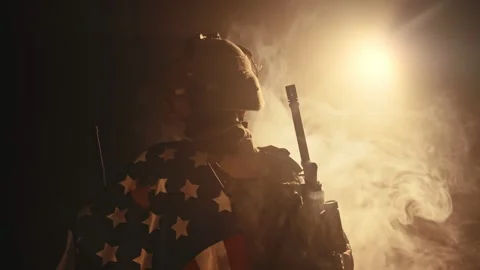 Soldier standing with his back to us in the dark holding USA national flag Video stock 155983837