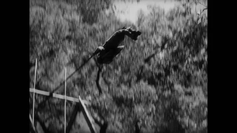 Soldier swinging into the air during basic training, 1940s Video stock 260257136