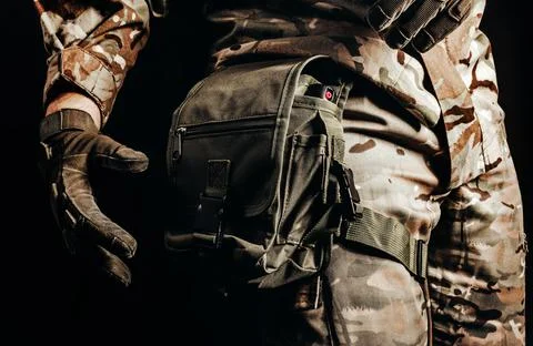 Soldier in tactical gloves using leg bag. Stock Photos