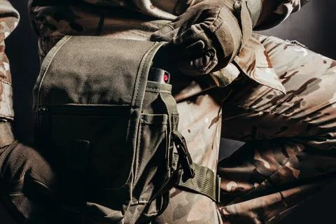 Soldier in tactical gloves using leg bag. Stock Photos