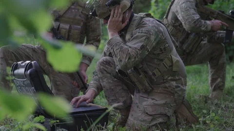 Soldier Taking an Order in His Ear Piece and Typing on the Computer Stock Footage 208769788