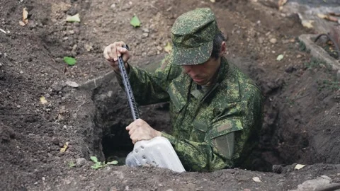 A soldier in uniform digging a trench Stock Footage 294182958
