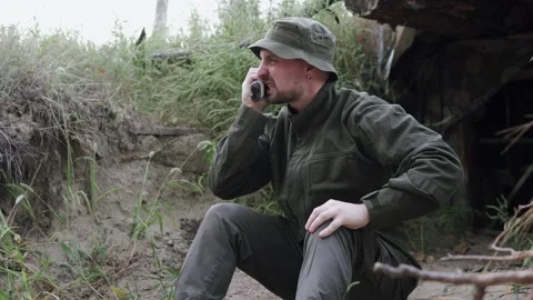 A soldier in uniform emotionally communicates with command via radio. Stock Footage 327915430