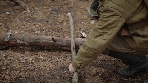 A soldier in the uniform of the Second World War chops firewood at a halt Stock Footage 113826820
