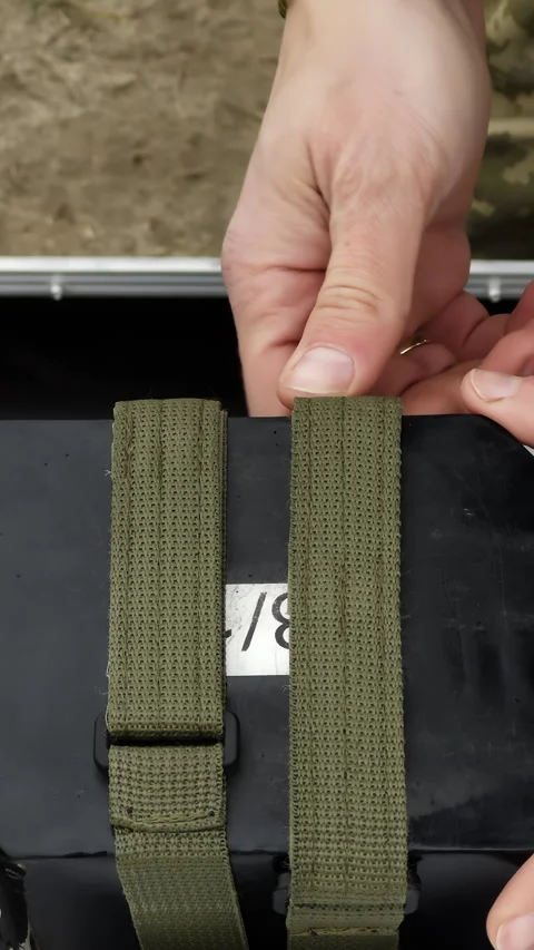 Soldier unties webbing straps to remove UAV from special bag Stock Footage 323840327