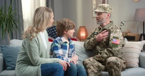 Soldier of us army talking with son and wife on couch Stock Footage 174156116