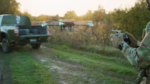 Soldier using drone for surveillance during a military operations near car Stock Footage 244080645