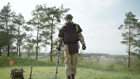 Soldier using mine detector, neutralizing mines, disarms a mine Video stock 255055324