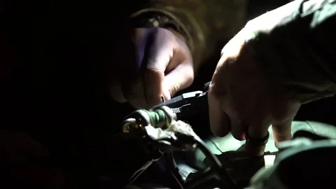 Soldier using pliers under torchlight Stock Footage 105231117
