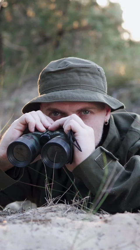 A soldier watches the enemy through binoculars. Stock Footage 327543725