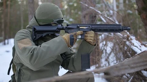 A soldier in winter sitting changing a store at a machine gun Stock Footage 83175871