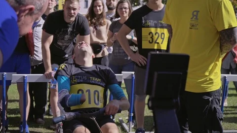 A soldier without a hand on a rowing machine. Competitions among the disabled. Stock Footage 120775871