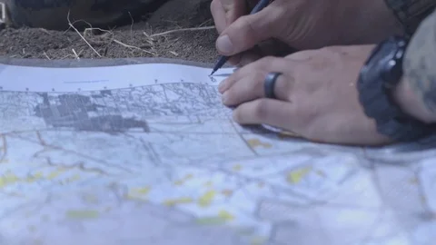 Soldier writing co-ordinates on map during land navigation exercise Stock Footage 92407989