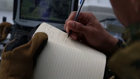 Soldier writing in notebook during cold weather mountain warfare training Stock Footage 105715878