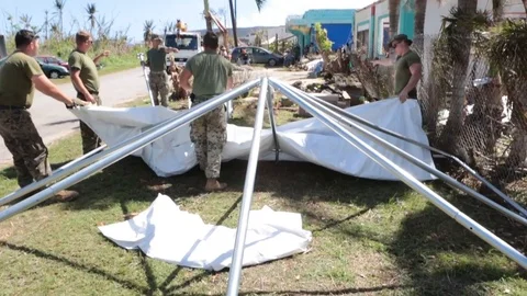 Soldiers assembling a tent in a yard 1 Stock Footage 109614697