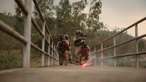 Soldiers  in camouflage uniforms aiming with their rifles ready to fire dur.. Stock Footage 293795053