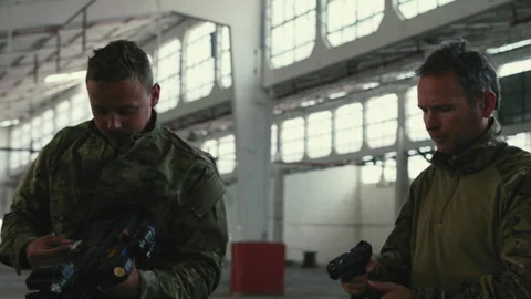Soldiers checking gear and weapons in empty warehouse Stock Footage 275093186