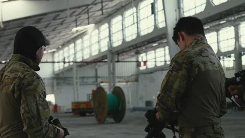 Soldiers cleaning and checking weapons in empty warehouse Stock Footage 275093285