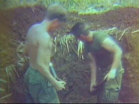 Soldiers dig a bunker and another soldier tries to repair a tape recorder in aƒ Stock Footage 75280158