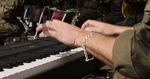 Soldier’s hands playing electronic keyboard during military band show. 库存影片 313834048
